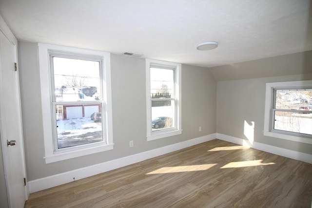 additional living space with lofted ceiling and hardwood / wood-style floors