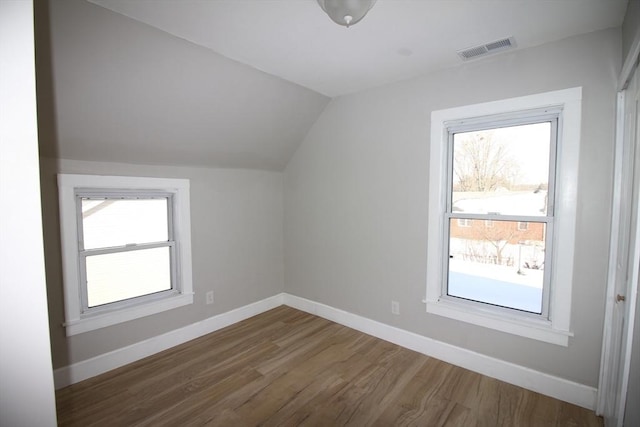 bonus room with hardwood / wood-style flooring and vaulted ceiling