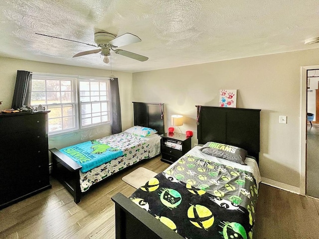 bedroom with a textured ceiling, wood finished floors, and ceiling fan