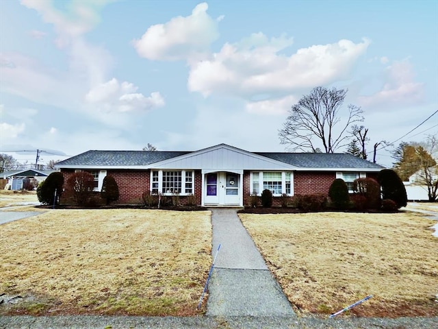 ranch-style home featuring a front yard and brick siding