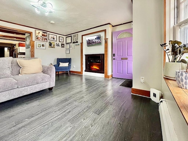 living area with crown molding, baseboards, a lit fireplace, wood finished floors, and a textured ceiling