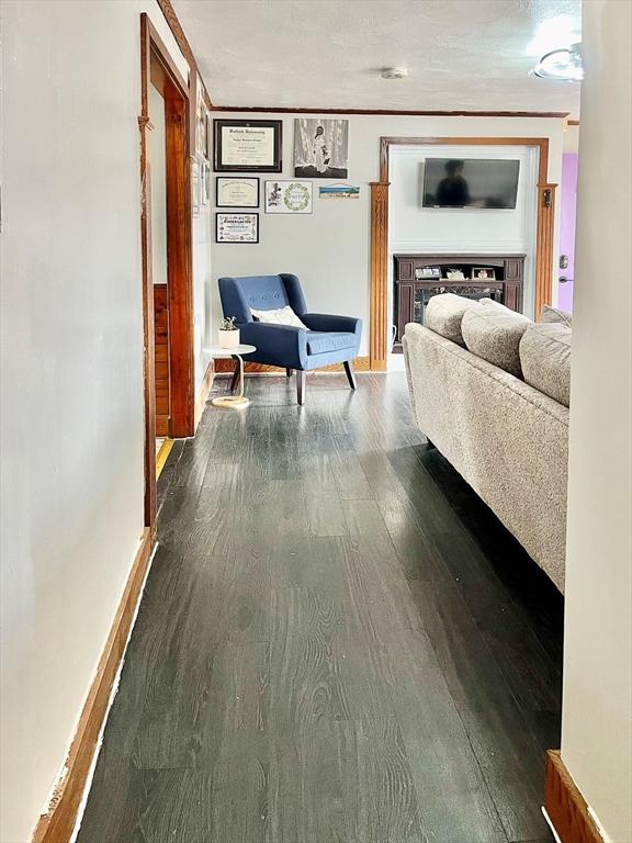 hall featuring dark wood-type flooring and baseboards