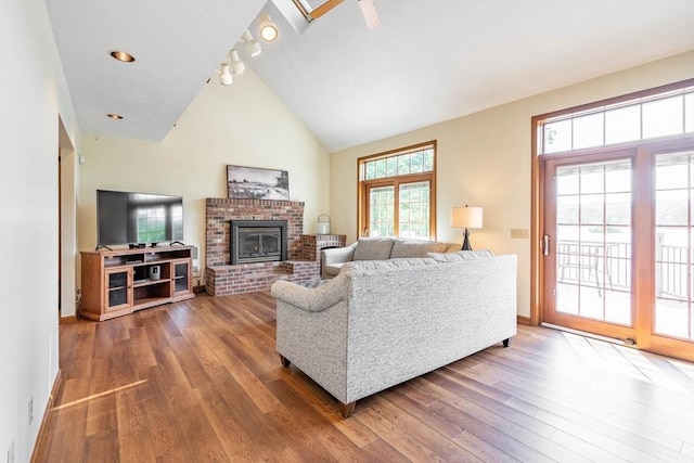 92 Wallace Ave, Auburn, MA 01501 - living room with a brick fireplace, wood finished floors, rail lighting, and high vaulted ceiling