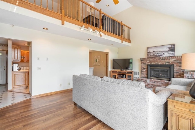 92 Wallace Ave, Auburn, MA 01501 - living room with high vaulted ceiling, light wood finished floors, a ceiling fan, and a brick fireplace