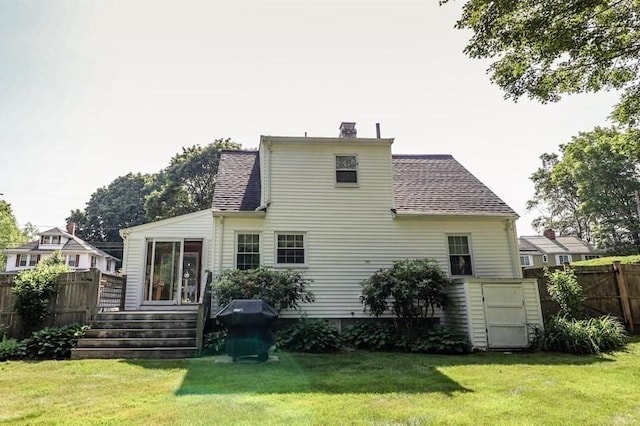 53 Perkins St, Stoneham, MA 02180 - back of property with a deck, roof with shingles, and a chimney