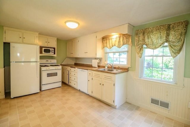 53 Perkins St, Stoneham, MA 02180 - kitchen with white appliances, wainscoting, and white cabinetry