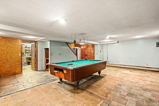 playroom featuring a textured ceiling, pool table, a baseboard radiator, and stone finish flooring