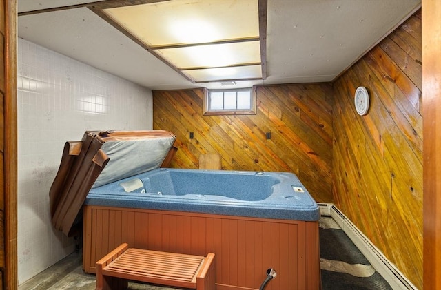 misc room featuring wood walls, a baseboard radiator, and a hot tub