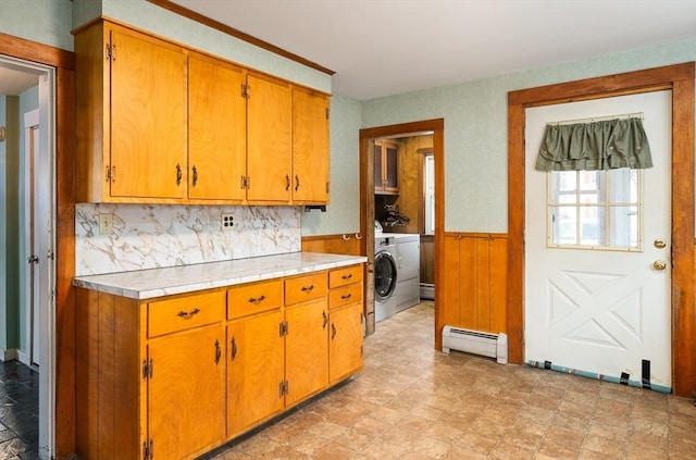 kitchen featuring a wainscoted wall, a baseboard radiator, washer / clothes dryer, and brown cabinetry