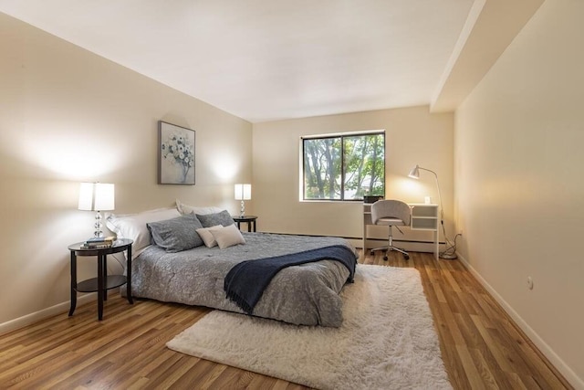 bedroom featuring baseboards and wood finished floors