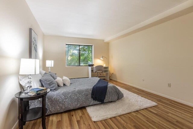 bedroom featuring baseboards and wood finished floors