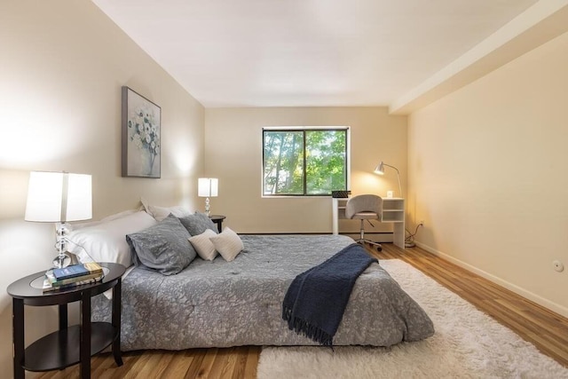 bedroom featuring baseboards and wood finished floors