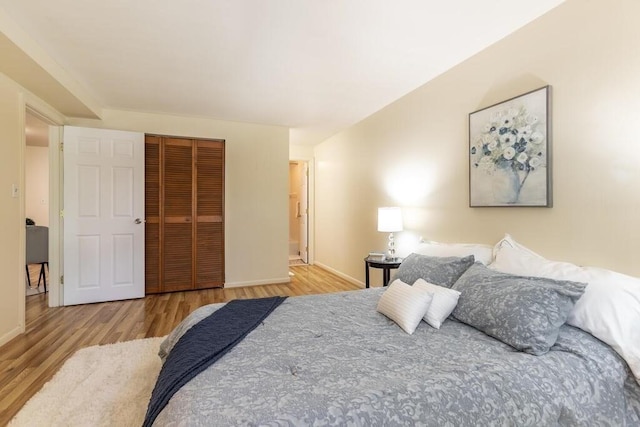 bedroom featuring baseboards, a closet, and wood finished floors