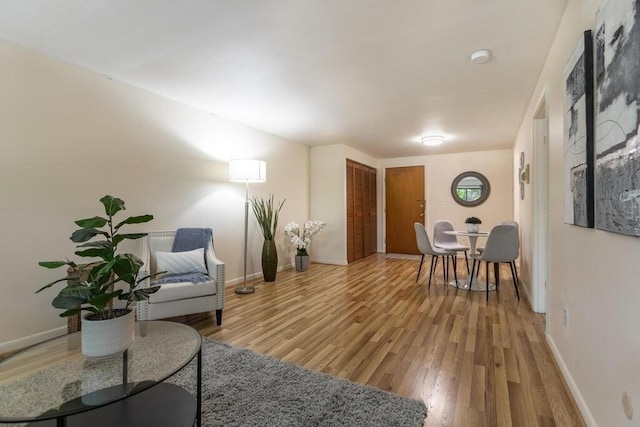 living area with baseboards and wood finished floors