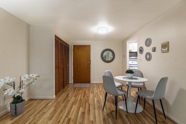 dining area with light wood-style floors and baseboards