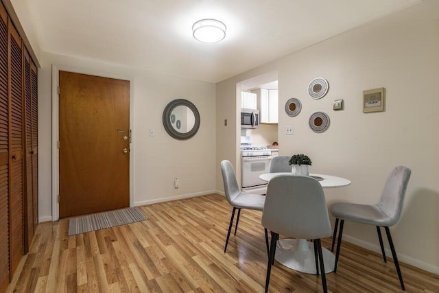 dining room with baseboards and light wood-style flooring