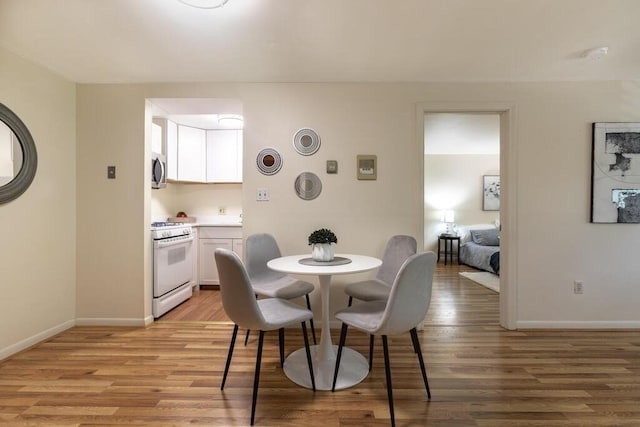 dining room with baseboards and light wood-style flooring