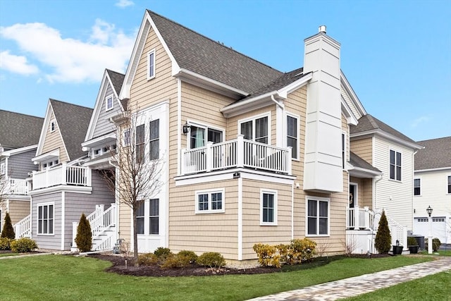 view of front of house with a front yard, cooling unit, and a balcony