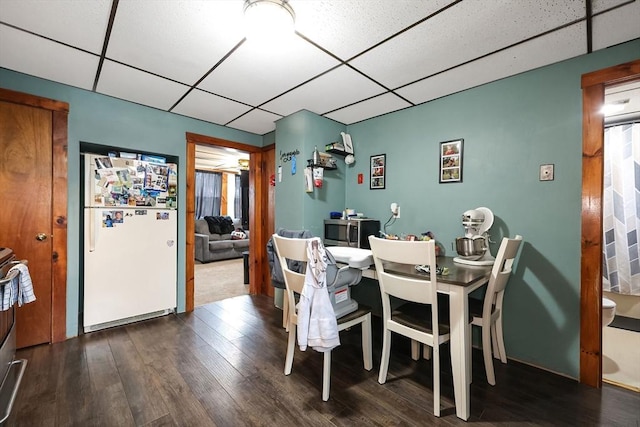 dining room with dark hardwood / wood-style flooring and a drop ceiling