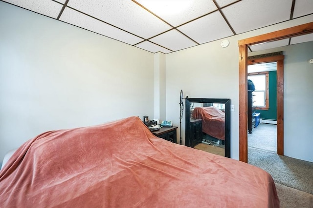 bedroom featuring a baseboard radiator, carpet floors, and a drop ceiling