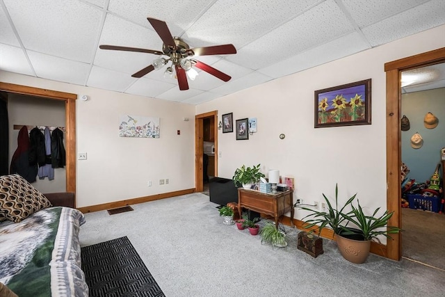 living room with carpet floors, a paneled ceiling, and ceiling fan