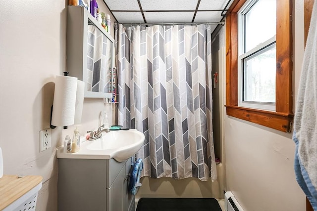 bathroom featuring vanity, a paneled ceiling, shower / bathtub combination with curtain, and a baseboard radiator