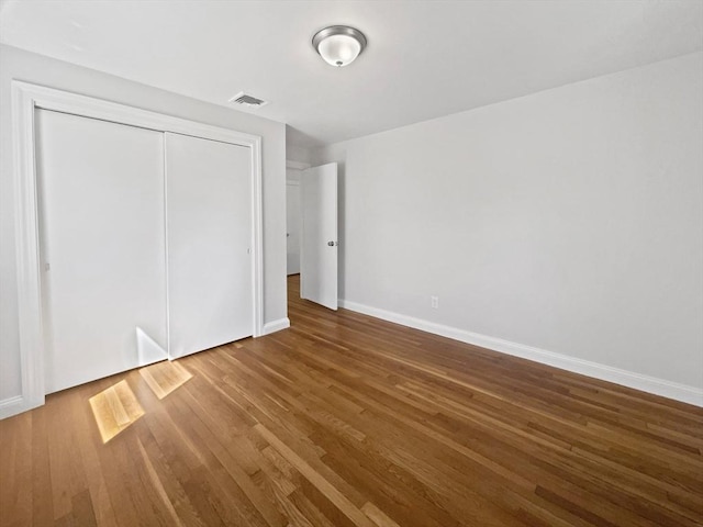 58 Morse Ave, Brockton, MA 02301 - unfurnished bedroom featuring visible vents, baseboards, wood finished floors, and a closet