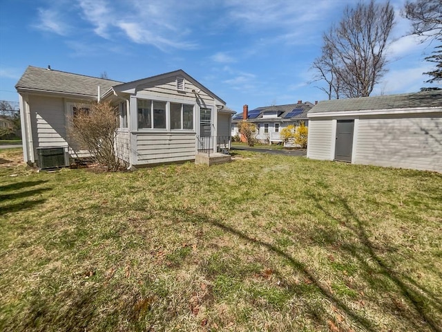 58 Morse Ave, Brockton, MA 02301 - back of house featuring a sunroom, an outbuilding, a yard, and central AC
