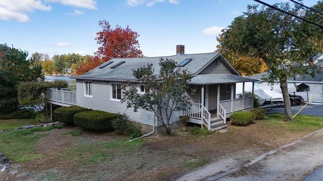 view of front of home with covered porch and a chimney