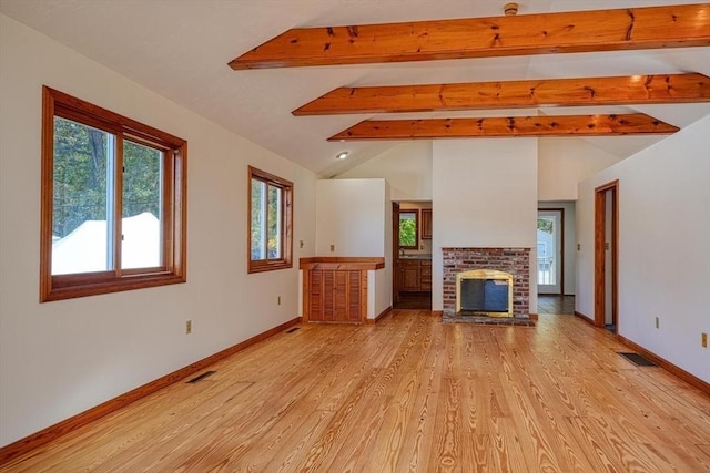 unfurnished living room with lofted ceiling with beams, light wood-style floors, a fireplace, and visible vents