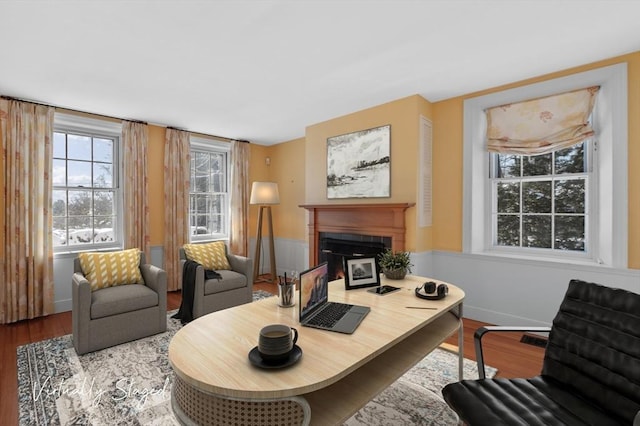 living area with light wood-style floors, a fireplace with flush hearth, and baseboards