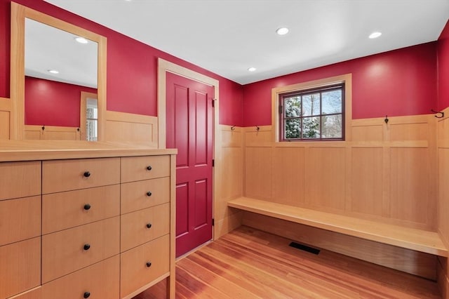 interior space with light wood-style floors, recessed lighting, wainscoting, and visible vents