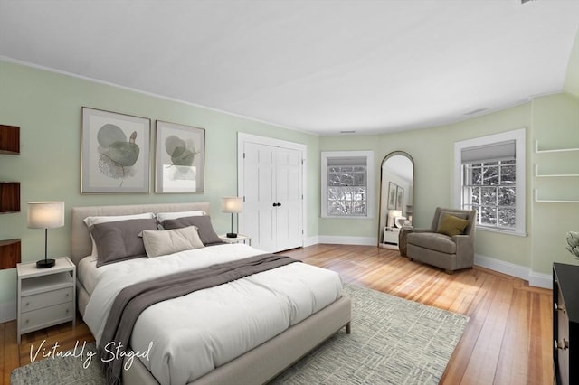 bedroom featuring a closet, baseboards, and wood finished floors