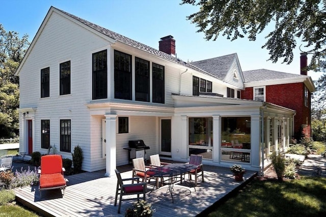 rear view of house with a chimney and a deck