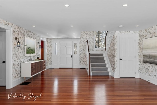 foyer featuring recessed lighting, wood finished floors, baseboards, stairway, and wallpapered walls