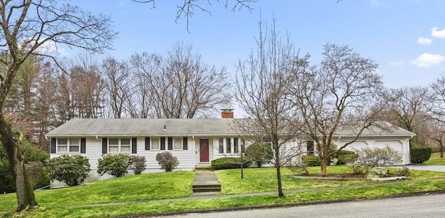 ranch-style home featuring driveway, a chimney, a front yard, and a garage