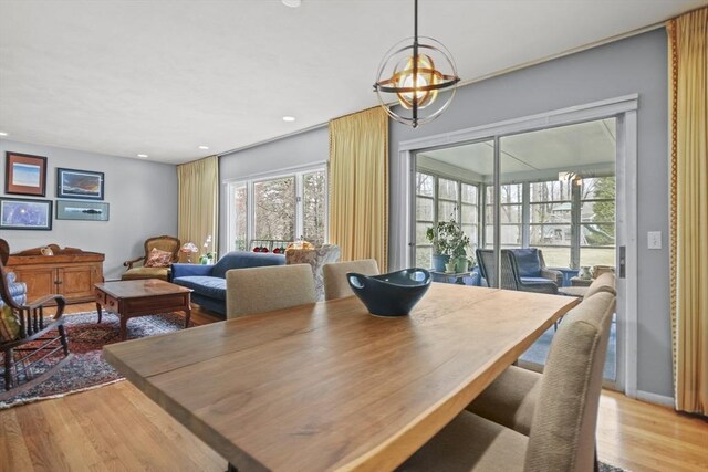 dining space featuring baseboards, a notable chandelier, wood finished floors, and recessed lighting