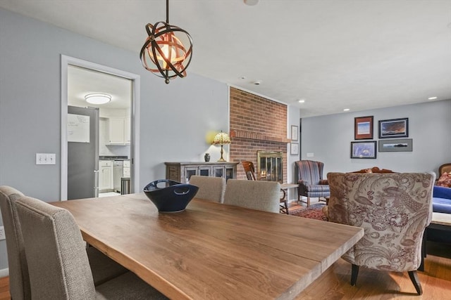 dining room with recessed lighting, wood finished floors, and a fireplace