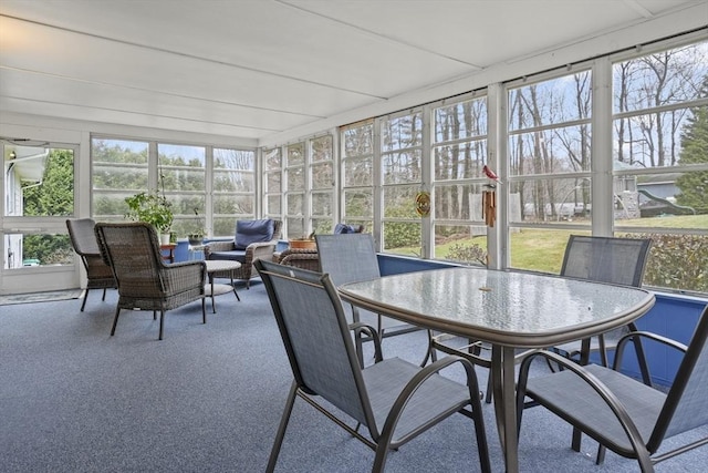 sunroom / solarium featuring outdoor dining area, outdoor lounge area, and carpet flooring