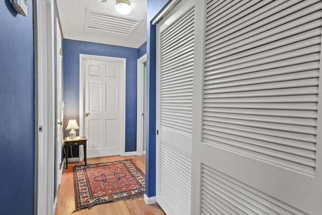 corridor featuring light wood-type flooring, visible vents, and baseboards