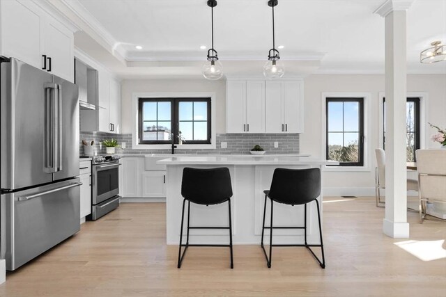 40 Maplewood Unit 40, Boston, MA 02132 - kitchen featuring light countertops, ornamental molding, a kitchen bar, tasteful backsplash, and appliances with stainless steel finishes