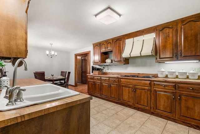 5 Villa Ln, Peabody, MA 01960 - kitchen with premium range hood, black electric stovetop, butcher block countertops, and light tile patterned flooring