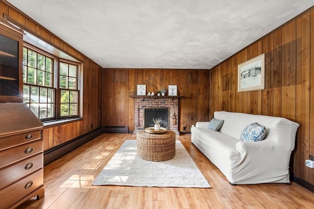 5 Villa Ln, Peabody, MA 01960 - living area featuring wooden walls, a brick fireplace, light wood-style flooring, and baseboard heating