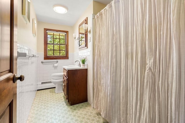 5 Villa Ln, Peabody, MA 01960 - bathroom featuring baseboard heating, vanity, tile walls, a wainscoted wall, and tile patterned floors