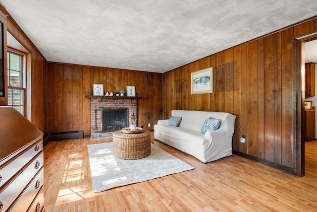 5 Villa Ln, Peabody, MA 01960 - living area featuring wood walls, a baseboard heating unit, a brick fireplace, and light wood-type flooring
