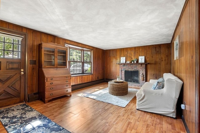 5 Villa Ln, Peabody, MA 01960 - living room featuring wooden walls, light wood-style floors, and a brick fireplace