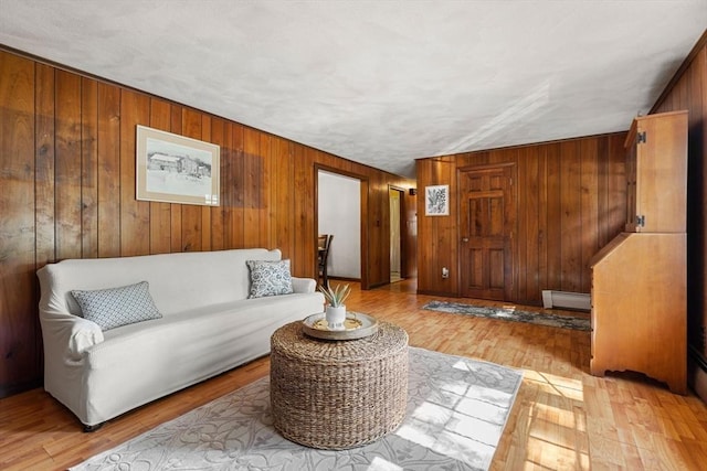 5 Villa Ln, Peabody, MA 01960 - living area with a baseboard heating unit, wooden walls, and wood finished floors