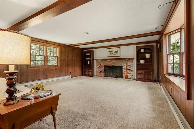 5 Villa Ln, Peabody, MA 01960 - living area featuring baseboard heating, beamed ceiling, wood walls, light colored carpet, and a brick fireplace