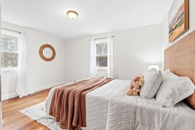 bedroom featuring light wood-style floors and baseboards