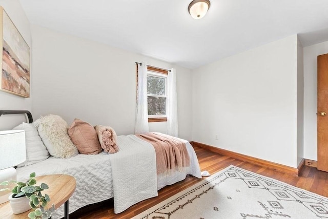 bedroom with baseboards and wood finished floors